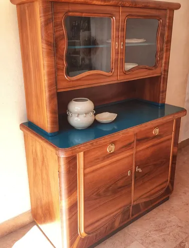 Aparador de madera restaurado con vitrina y sobre azul en Mallorca