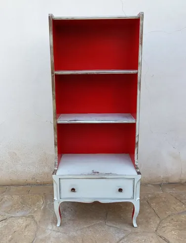 Estantería restaurada en blanco con interior rojo llamativo en Mallorca